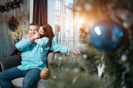 young happy couple in love, hugging near christmas tree at cozy home