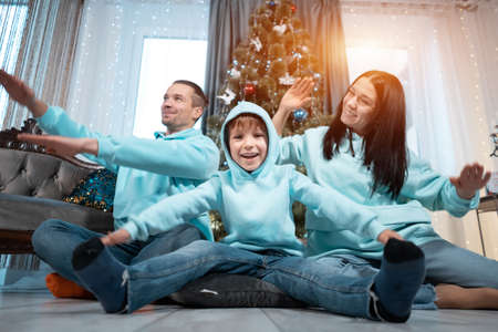 happy family with mother father and son have fun on christmas decorating treeの写真素材