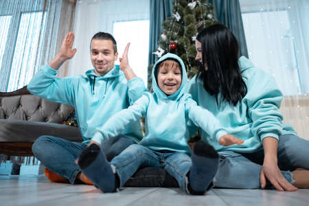 happy family with mother father and son have fun on christmas decorating treeの写真素材