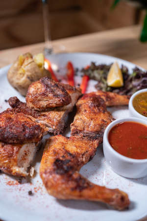 Georgian cuisine dish roasted chicken tapaka with sauce on plate in restaurantの写真素材
