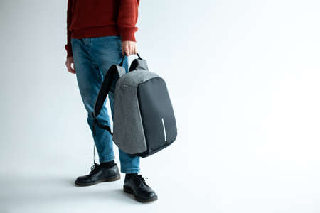 stylish hipster male holding modern backpack bag on white backgroundの写真素材