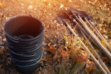 closeup of plastic bucket and shovel on ground or gardening tools for plantingの写真素材
