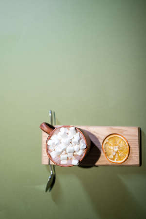 top view of cup with hot cocoa drink and marshmallow on yellow backgroundの写真素材