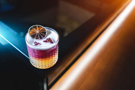 fresh stylish layered pink sour grapefruit cocktail with foam and iceの写真素材