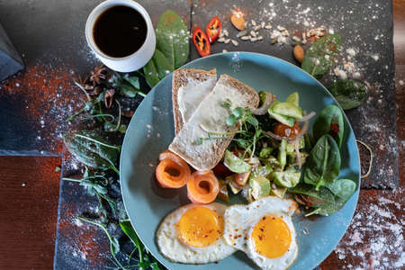 fresh breakfast with fried eggs, bread, avocado, red fish salmon and coffeeの写真素材