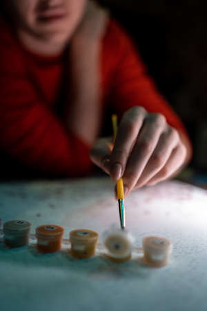 person hand drawing picture with painting by numbers with brush, acrylic, macroの写真素材