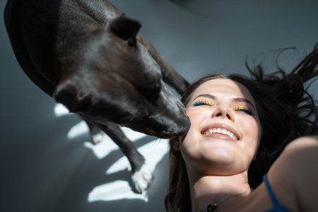 young beautiful female play with staffordshire terrier dog at hoeの写真素材