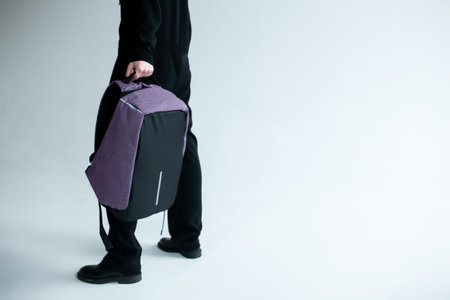 stylish hipster person holding modern backpack bag on white background