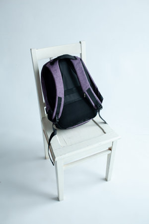 modern stylish backpack on chair studio shot