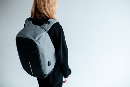 stylish hipster person holding modern backpack bag on white backgroundの写真素材