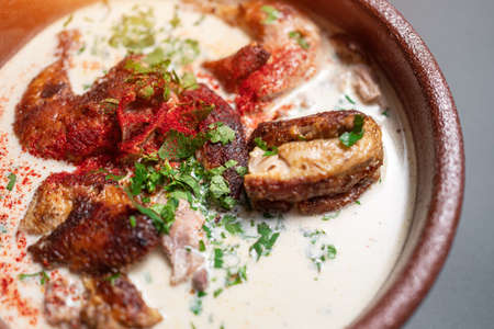 closeup of georgian chkmeruli chiken meat with cream sauce and cilantro in bowlの写真素材