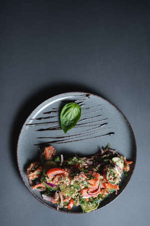 top view of georgian salad with tomato, cucumber and walnut on black backgroundの写真素材