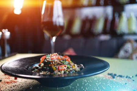 closeup of vegetable salad with grilled veal meat on black plate in restaurantの写真素材