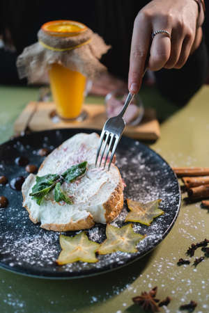 female eat meringue roll cake with mascarpone, mint and carambola in restaurantの写真素材