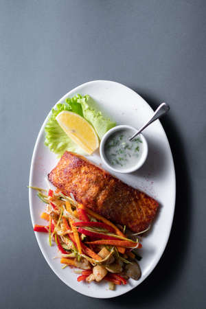 fresh red grilled salmon steak with vegetable salad and sweet sauce, closeupの写真素材