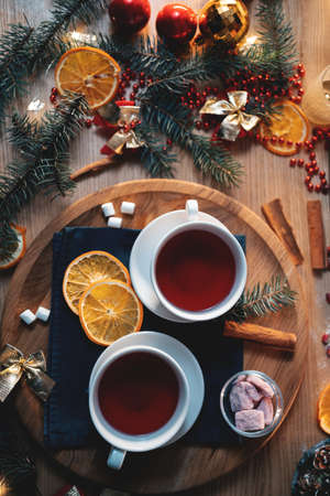 two cups of black or berry red christmas tea, decorated candle, top view flatlayの写真素材