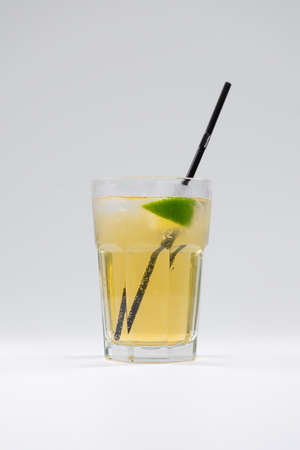 fresh cold fruit citrus lemonade drink with lime or lemon, ice, straw isolatedの写真素材