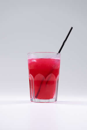 fresh cold fruit drink with red grape juice, ice, straw isolatedの写真素材
