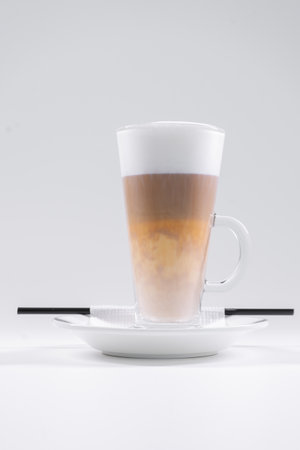 tasty italian latte coffee with straw and saucer isolated on white backgroundの写真素材
