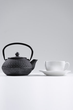 stylish tea kettle or teapot with cup isolated on white backgroundの写真素材