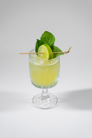 yellow alcohol cocktail with lime, mint, ginger, honey, isolated on whiteの写真素材