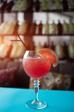 red grapefruit juicy cocktail with straw in bar, cafe or restaurant on tableの写真素材
