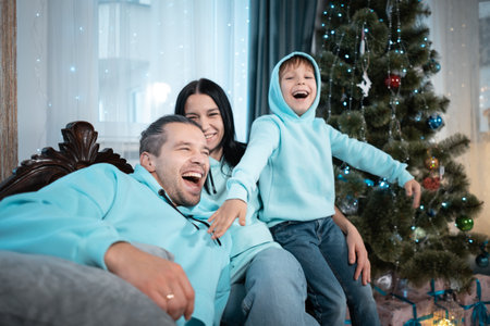 happy family with mother father and son have fun on christmas decorating treeの写真素材