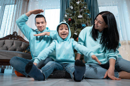happy family with mother father and son have fun on christmas decorating treeの写真素材