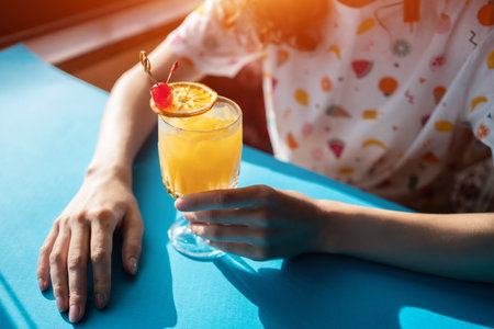 female drink fresh tequila sunrise orange cocktail with slice of citrus in barの写真素材