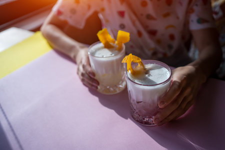 female drink foam sour pink and yellow cocktail with egg in barの写真素材
