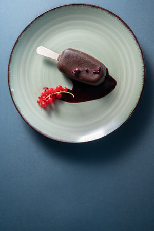 cake pop dessert or ice cream covered with chocolate on plate in cafe, top viewの写真素材