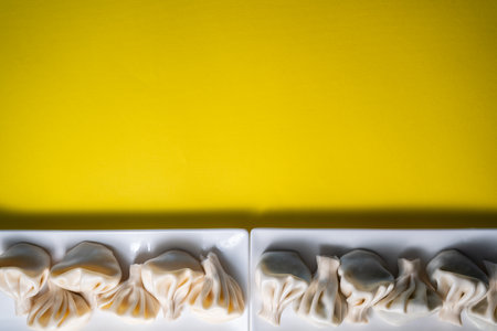 traditional georgian khinkali dumplings flatlay, copyspace, yellow backgroundの写真素材