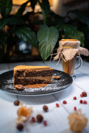 closeup of chocolate nut cake with walnut and physalis on dark plateの写真素材