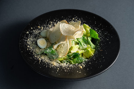 light caesar salad without meat on black plate on dark backgroundの写真素材