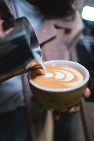 barista making fresh tasty cappuccino or latte coffee with hot milk, restaurantの写真素材