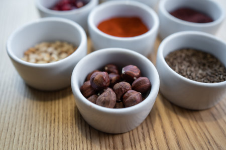 set of spices on wooden background, pomegranate, pine nut, hazelnutの写真素材