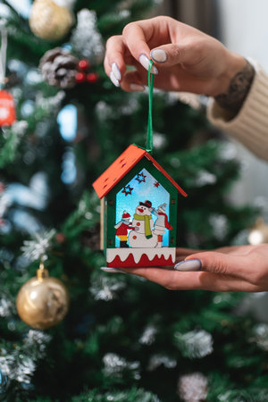 person decorating christmas tree with toys at new year eveの写真素材