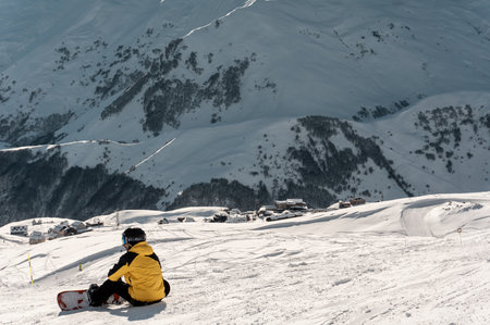 snowboarder have rest on slope, ski and snowboarding at winter mountain on trackの写真素材