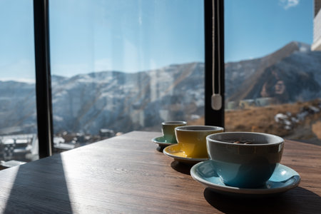 three cups with brown coffee beans on wooden tableの写真素材