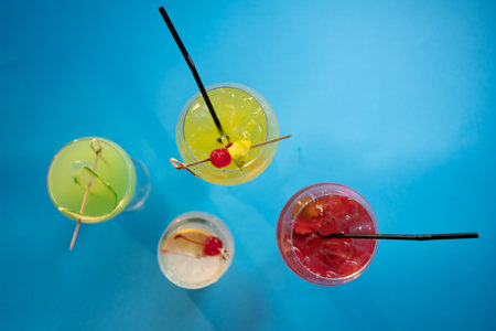 set of color alcohol stylish cocktails on blue background, green, red, yellowの写真素材