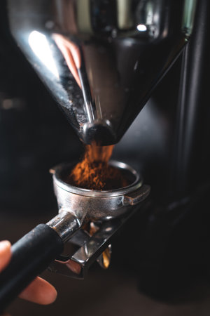 barista with holder grinding coffee beans with professional grinder machineの写真素材