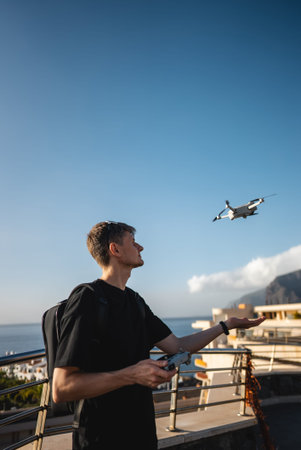 young photographer launching quadcopter drone from hand with remote controllerの写真素材