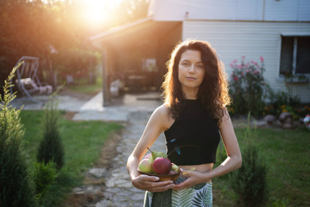 young woman hold bowl with apples and pears, harvest gatheringの写真素材