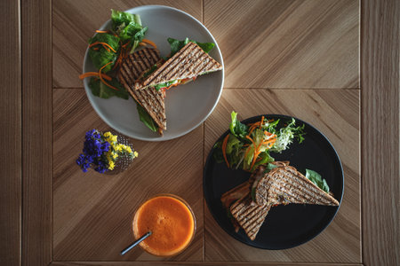 toasted vegetarian sandwich with mozzarella cheese and tomato and orange juiceの写真素材