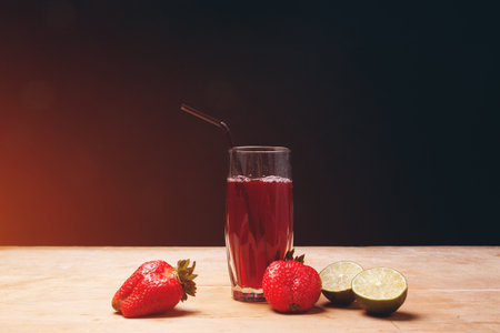 fruit juice or lemonade with strawberry and lime on wooden backgroundの写真素材