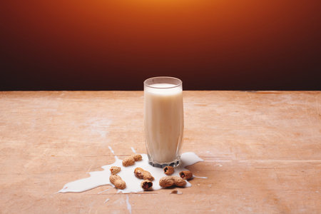 healthy diary food on rustic, spilled milk with peanuts on wooden background
