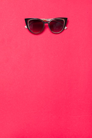 luxury fashionable sunglasses lying on red or pink background, flatlay top viewの写真素材