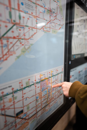 person at subway station looking at transport city map, tourist planning route