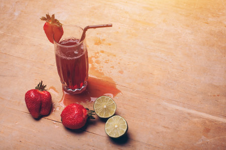 fruit juice or lemonade with strawberry and lime on wooden backgroundの写真素材