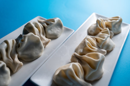 traditional georgian khinkali dumplings with cheese or meat on blue backgroundの写真素材